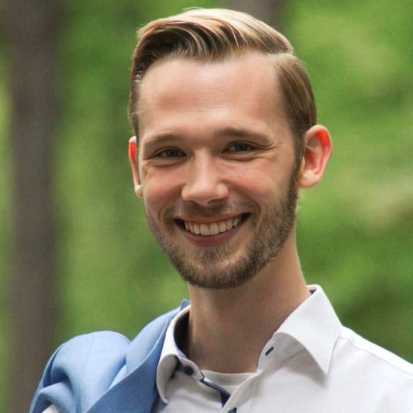 Lächelnder Mann im Anzug in einem Wald